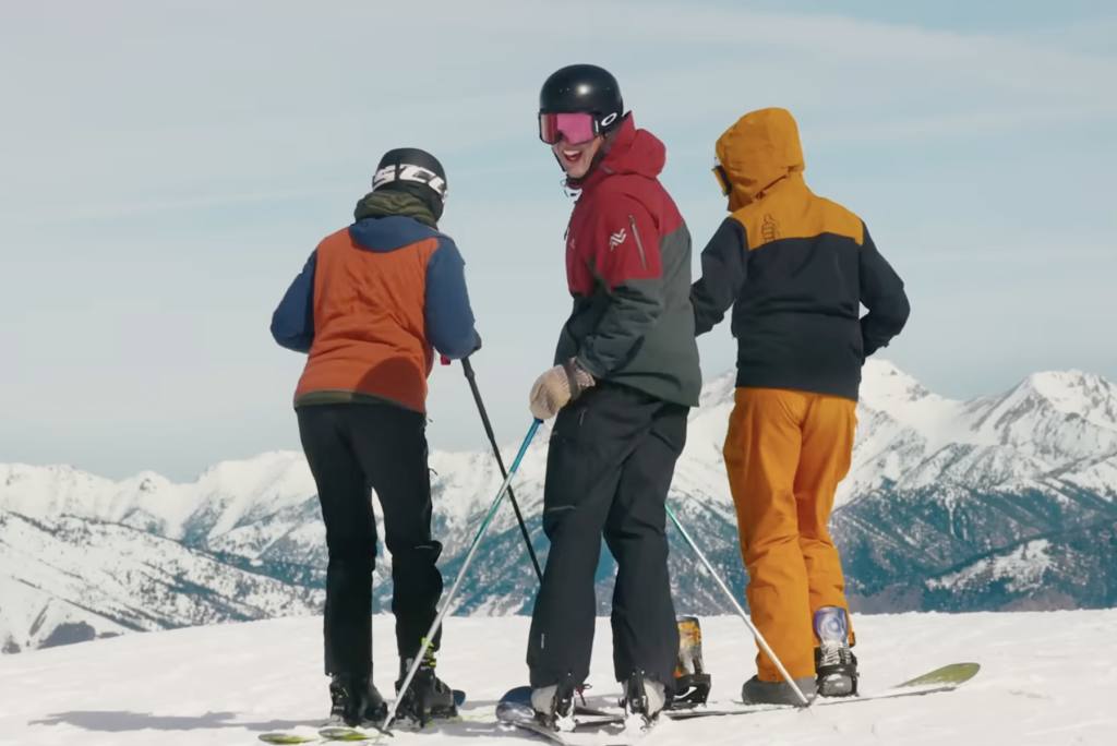 A frame from the 'Make the Sunny Side Your Own' campaign film: three skiers atop Sun Valley's Bald Mountain. The creator-led campaign extends 'Ski on the Sunny Side' into its third year.